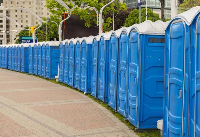 a row of portable restrooms set up for a large athletic event, allowing participants and spectators to easily take care of their needs in Bedford Park